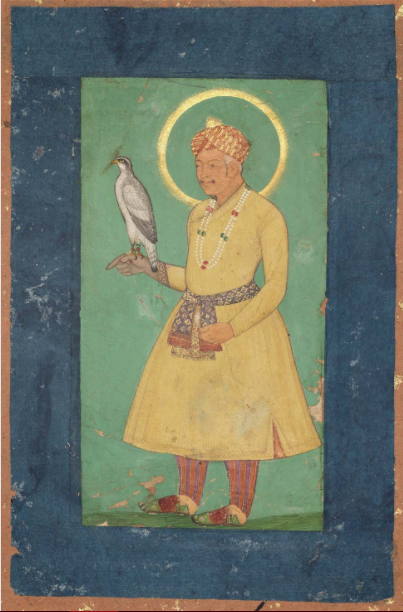 A Mughal miniature painting of an emperor with a golden halo, wearing a yellow robe, patterned sash and turban, standing on a green ground with a hunting falcon perched on his hand.