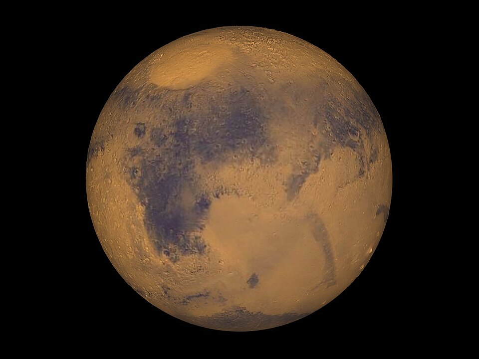 Full-disk true-color view of the planet Mars, an ochre-red globe with darker surface markings, set against black space