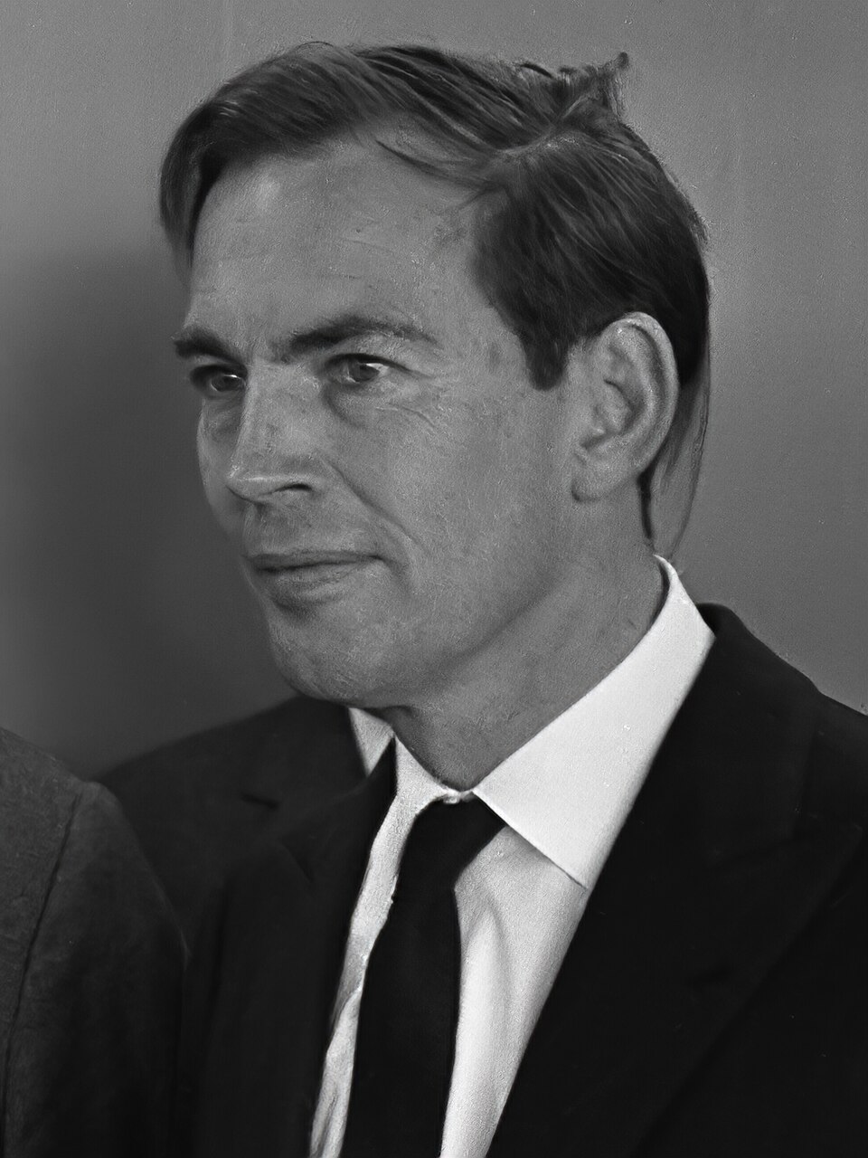 A black-and-white portrait of a man with combed-back hair in a dark suit and tie (Christiaan Barnard, 1968).