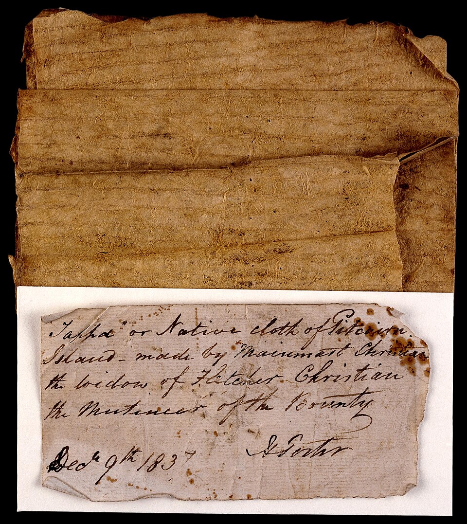 A rectangular piece of aged brown bark cloth (tapa) with a horizontally ridged texture, shown above a handwritten historical label.