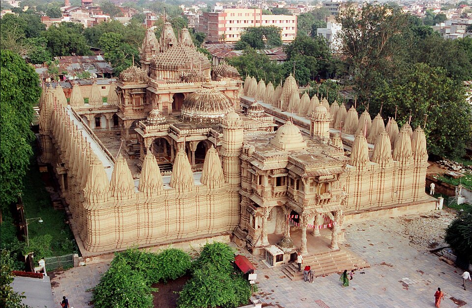 Aerial view of the carved sandstone Hutheesing Jain temple with its rows of small spires, hemmed in by the buildings of Ahmedabad