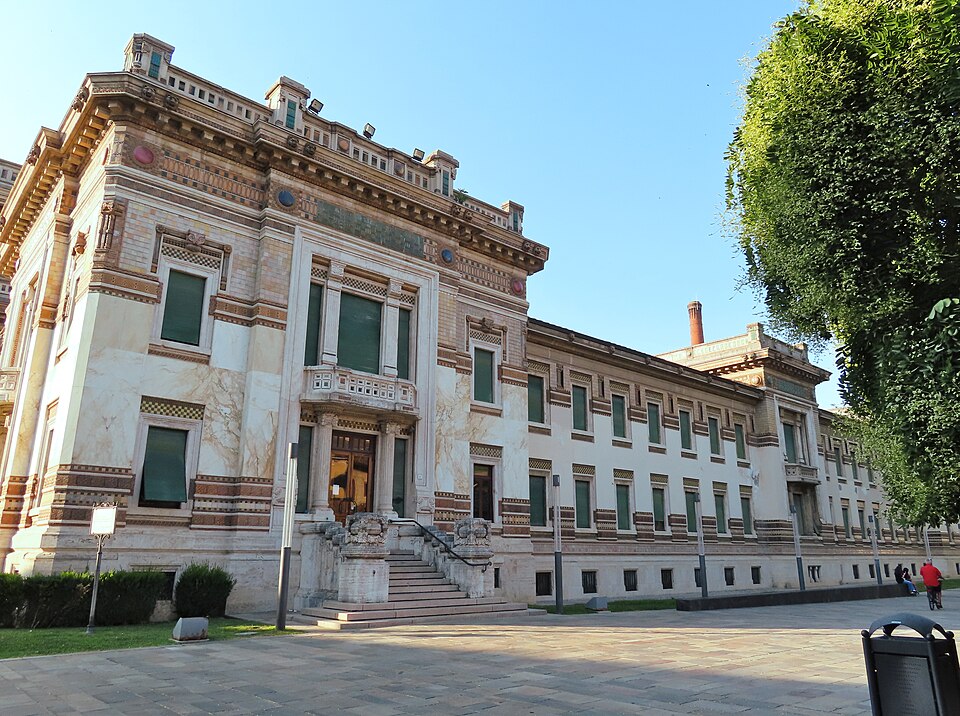 The marble and majolica-decorated facade of the Terme Berzieri spa building at Salsomaggiore Terme, seen from the square in sunlight