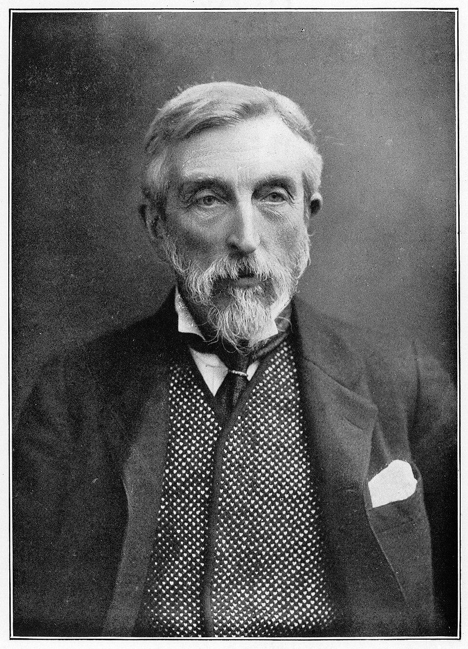 Black-and-white photographic portrait of an elderly Charles Booth with a white pointed beard, in a dark suit and patterned waistcoat