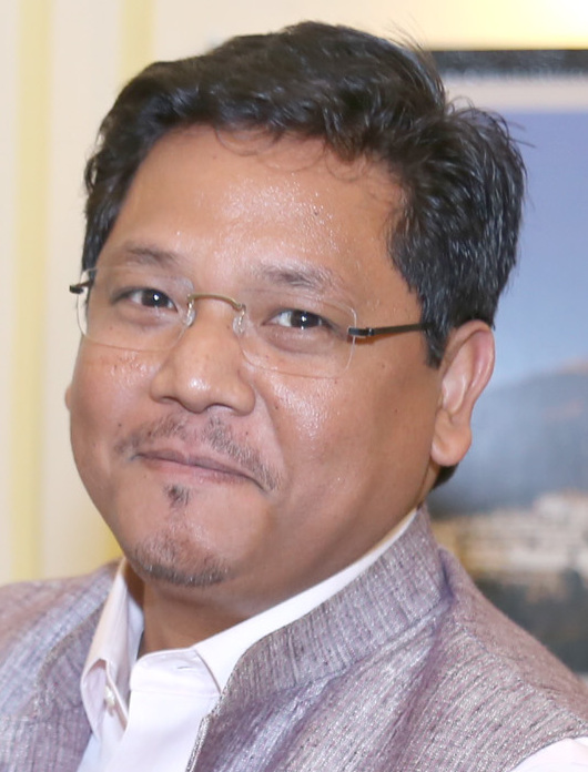 Head-and-shoulders portrait of Conrad Sangma, wearing rimless glasses and a grey jacket over a white shirt