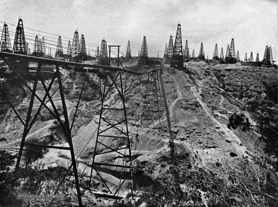 A dense forest of wooden oil derricks crowding the eroded ridges of the Yenangyaung oil field in an early twentieth-century photograph