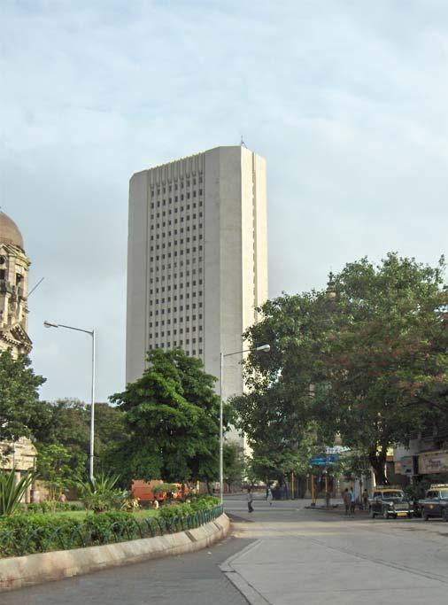 The tall pale concrete tower of the Reserve Bank of India central office rising above tree-lined Mint Road in Mumbai