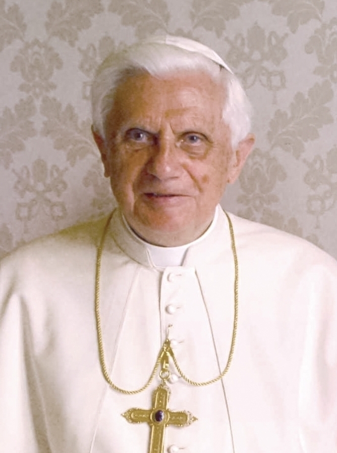 Portrait of Pope Benedict XVI in a white papal cassock and zucchetto, wearing a gold pectoral cross