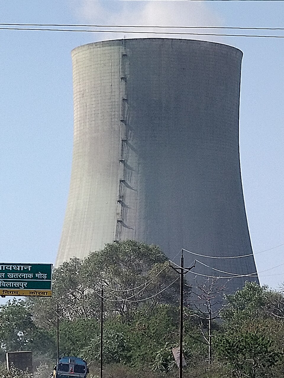 A large hyperboloid concrete cooling tower of the coal-fired CSEB West thermal power plant at Korba, Chhattisgarh, seen against the sky