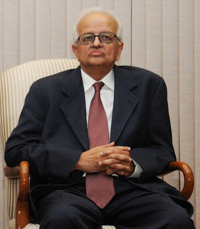 Bimal Jalan, an elderly man in a dark suit and maroon tie with glasses, seated in an armchair