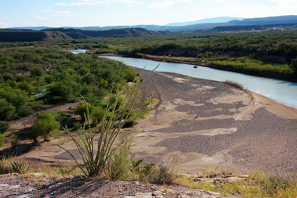 The Rio Grande river winding through arid scrub and gravel bars with distant mountains in Big Bend National Park, Texas, along the United States-Mexico border