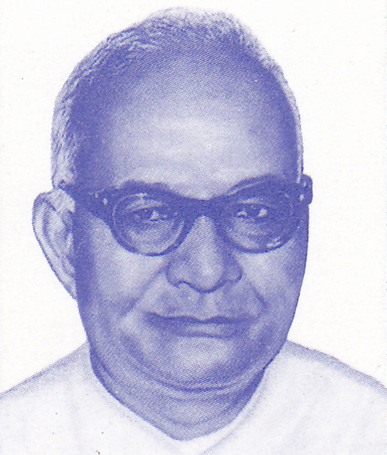 A head-and-shoulders portrait of a middle-aged bald man in thick-rimmed spectacles and a white kurta, printed in blue monochrome ink
