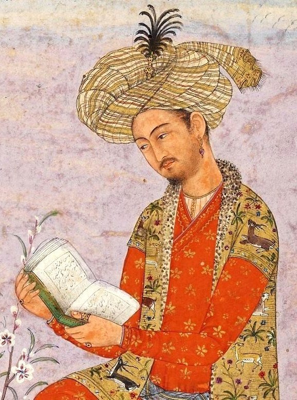 A Mughal miniature portrait of Babur seated in a red flowered robe and a large plumed turban, reading from an open book held in both hands