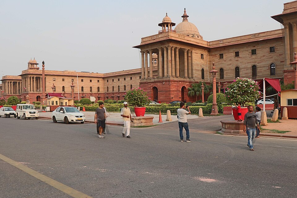 The red-and-buff sandstone Secretariat Building known as North Block on Raisina Hill in New Delhi, with its columned portico, chhatri and dome, seen from the road